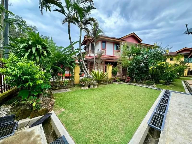 Exterior type: detached bungalow; features: manicured lawn, tropical landscaping, mature palm trees, flower beds, stone-paved walkway, fenced garden, two-storey structure, red painted facade, balconies on upper level, outdoor seating area; style: tropical-modern.