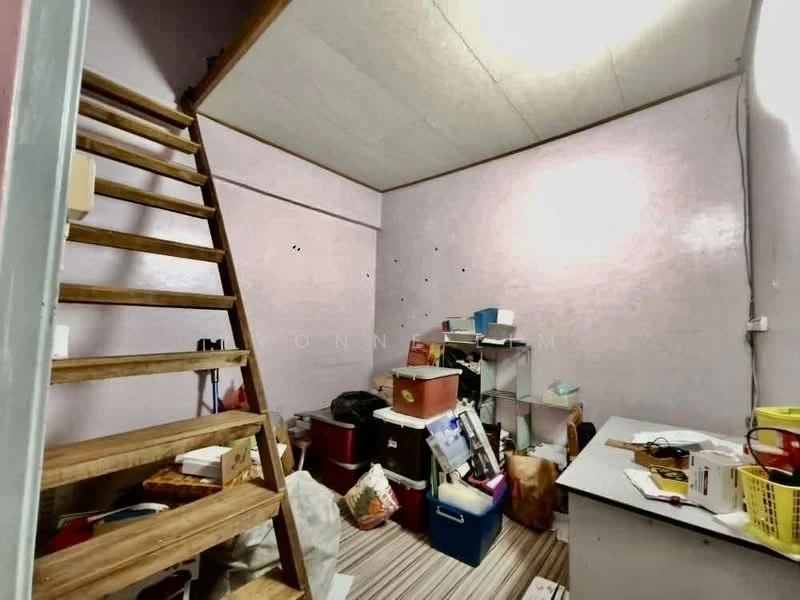 Room features: wooden staircase, pink painted walls, striped vinyl flooring, various storage boxes, shelves with items, cluttered space, light fixture on ceiling, desk with items.