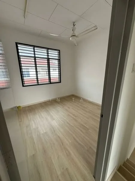 Room features: light wood laminate flooring, white painted walls, ceiling fan, large window with black metal grille, natural light from window.
