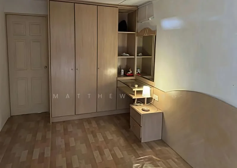 Bedroom features: light wood cabinetry, built-in wardrobe with sliding doors, desk with lamp, wooden flooring, neutral wall colour, single light fixture, decorative items on shelves, door with panel design; style: minimalist.