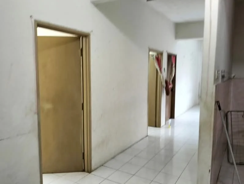 Room features: white painted walls, ceramic tile flooring, two wooden doors, one door partially open, light from adjacent room, neutral color scheme, no visible decor, plain ceiling.