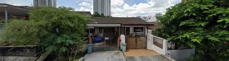 Exterior type: detached bungalow; features: single-storey building, brown wooden facade, sloping roof, front gate, paved driveway, manicured garden, mature trees, surrounded by greenery, adjacent to high-rise buildings, outdoor seating area; style: traditional.