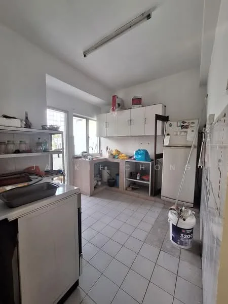 Kitchen features: white painted walls, tile flooring, single-bowl stainless-steel sink, chrome pull-down faucet, white cabinetry, countertop with space for appliances, refrigerator, open shelving, window for natural light, kitchen island, cleaning supplies visible, light fixture on ceiling.