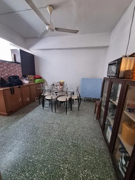Dining features: green speckled tile flooring, white painted walls, exposed ceiling, ceiling fan, dining table with six chairs, wooden sideboard, glass display cabinet, microwave, blue upholstered chair, boxes and items on sideboard.