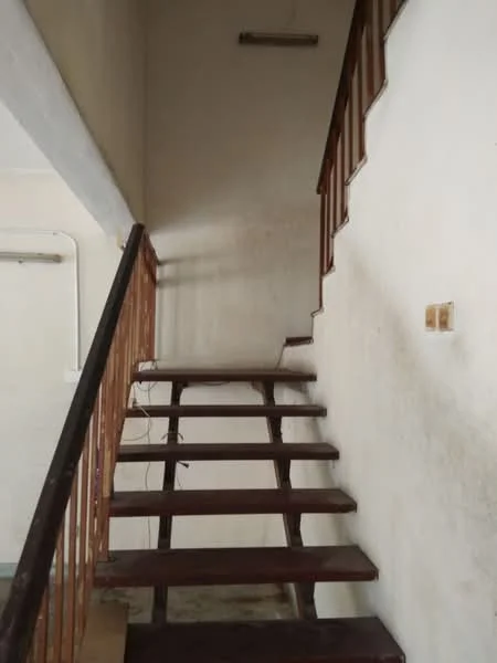 Room features: wooden staircase, white painted walls, exposed ceiling, metal railing, light fixture on ceiling, concrete flooring; style: minimalist.