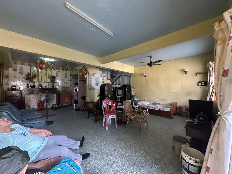 Living features: grey tiled flooring, yellow painted walls, exposed ceiling with fluorescent lighting, 5-blade ceiling fan, sofa set in dark grey, wooden coffee table, wooden TV cabinet, bed with mattress, wooden chairs, decorative curtains with floral pattern, wall-mounted TV, wall decorations, open space layout; style: traditional.