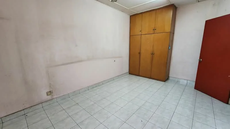 Room features: pink painted walls, white tiled flooring, built-in wooden wardrobe with doors, single red door, no visible lighting fixtures.