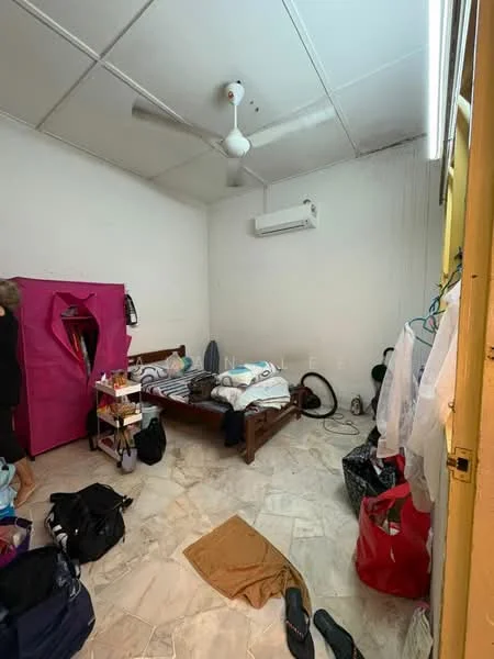 Bedroom features: white painted walls, marble tile flooring, 5-blade ceiling fan, wall-mounted split AC, double bed with bedding, wooden bed frame, clothes rack, various bags and personal items, light from ceiling, window with no visible treatment.