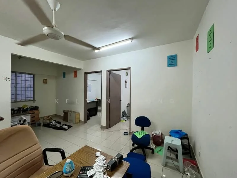 Room features: white painted walls, tile flooring, ceiling fan, fluorescent ceiling lights, window with grid, office chairs, cardboard boxes, wooden desk, plastic stools, cluttered space; style: minimalist.