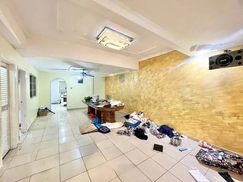 Room features: cream painted walls, gold accent wall, tile flooring, ceiling with recessed lighting, wall clock, dining table, various bags and personal items on the floor, open doorway leading to another room.