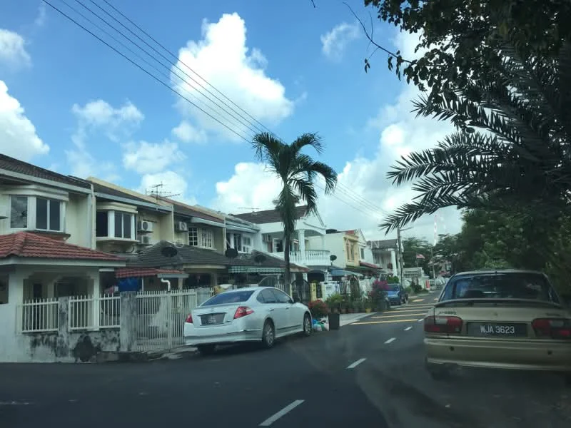 Exterior type: linked terrace house; features: two-storey linked terrace houses, white painted facade, red tiled roof, paved driveway, manicured front gardens, palm trees in front yards, street with clear blue sky, visible parked cars, residential street setting; style: modern.