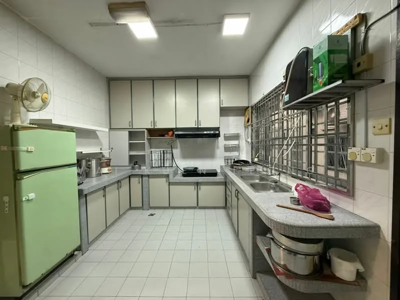 Kitchen features: green fridge, grey laminate countertop, stainless-steel double-bowl sink, chrome pull-down faucet, built-in gas stove, wall-mounted range hood, upper cabinets with cream doors, lower cabinets with grey trim, tile backsplash, white tiled walls, white tiled flooring, window with metal grille, ceiling-mounted fluorescent lights, open shelving, kitchen utensils on countertop.