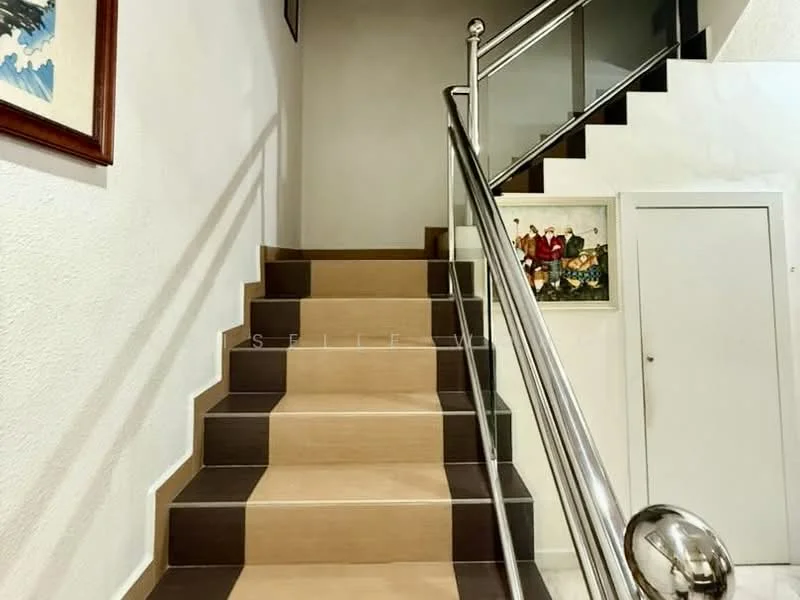 Room features: staircase with wooden steps, metal railing with polished finish, white painted walls, framed artwork on walls, doorway at the base of the stairs, light source illuminating the staircase; style: modern.
