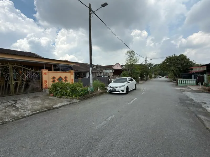 Exterior features: residential street, paved road, single-storey houses, front yard with fence, parked car, overcast sky, utility pole, sidewalk, greenery along the street.