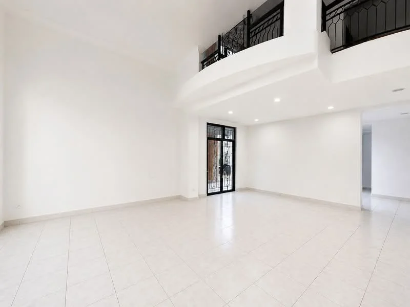 Living features: white painted walls, tile flooring, recessed downlights, large glass sliding door, iron railing on balcony, high ceiling, open layout, neutral color scheme; style: modern.