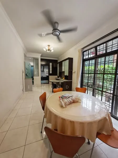 Dining features: round dining table with beige tablecloth, 4 wooden dining chairs, white painted walls, tile flooring, ceiling fan with light, chandelier, floor-to-ceiling windows, curtains, kitchen area visible in background, greenery visible through windows; style: modern; view: garden.