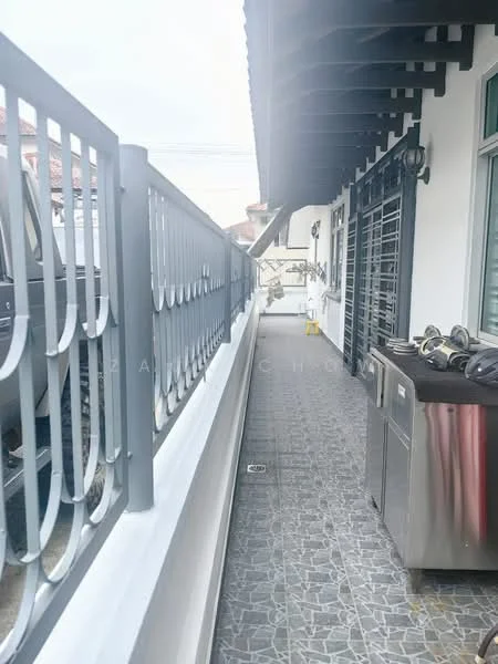 Room features: grey tiled flooring, metal railing, outdoor space, wall-mounted light fixtures, drainage grate, utility area with cabinets, overhead eaves, adjacent wall with windows; style: modern.