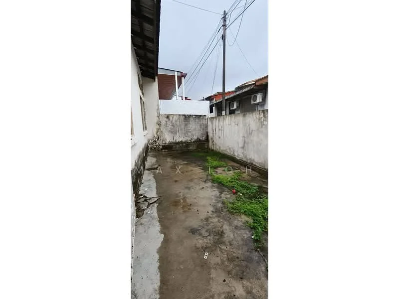 Exterior features: concrete flooring, exposed brick walls, overgrown grass, utility poles, grey cloudy sky.