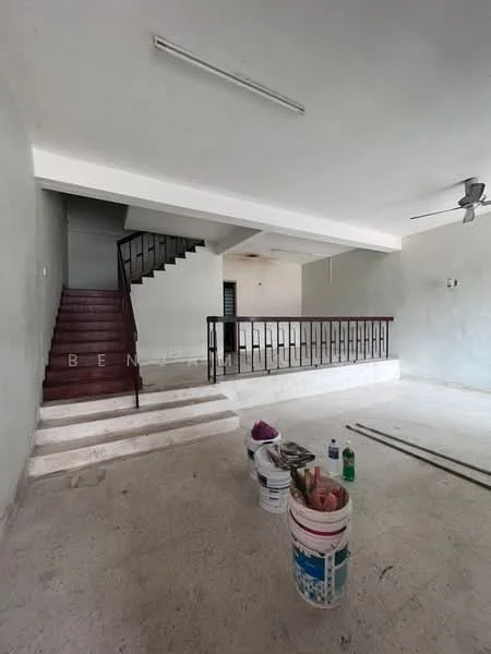 Living features: unfinished concrete flooring, white painted walls, staircase with wooden steps, metal railing, ceiling fan, recessed ceiling lights, open layout, large windows, no visible furniture, paint buckets and tools present.