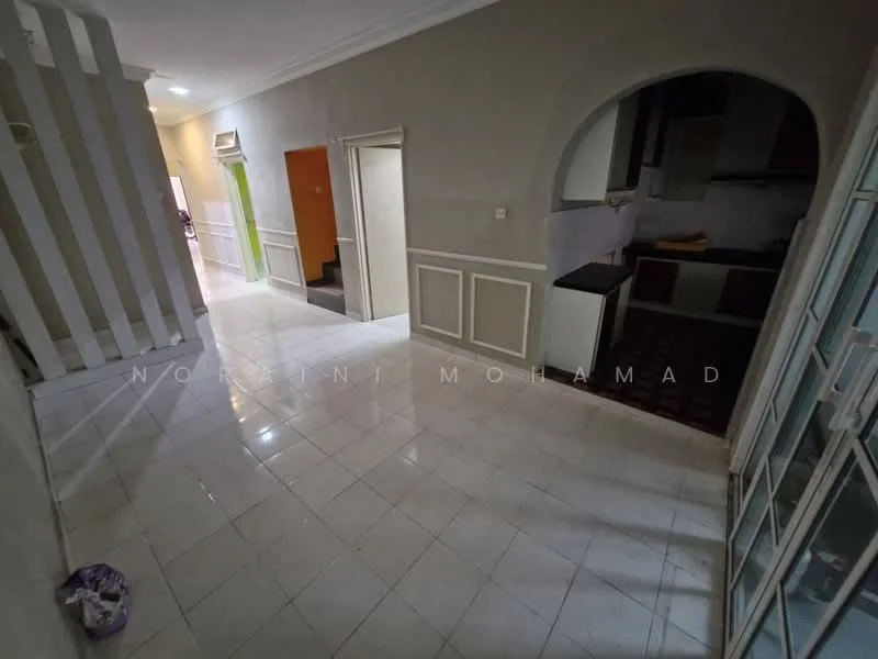 Room features: white painted walls, glossy white tile flooring, archway leading to kitchen, staircase visible in background, doorway leading to hallway, green door, kitchen area with dark cabinetry, light fixtures on ceiling; style: modern.