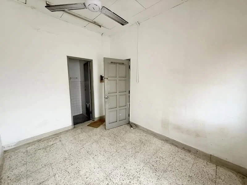 Room features: white painted walls, ceiling fan, terrazzo flooring, wooden door, door frame, light fixture, window opening, corner of adjacent room visible.
