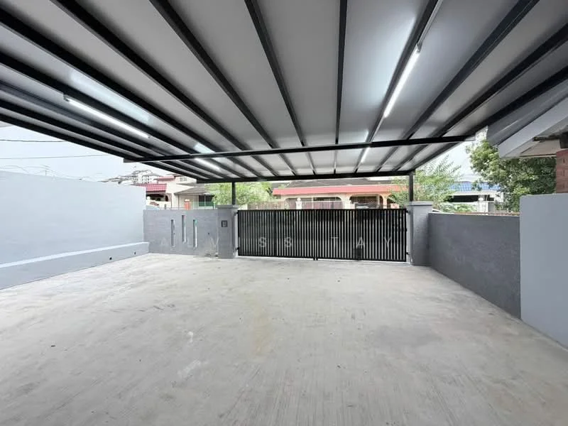 Exterior type: car porch; features: covered car porch with metal roofing, concrete flooring, sliding metal gate, grey painted walls, open space for parking, surrounded by low walls, landscaped area visible in background; style: modern.