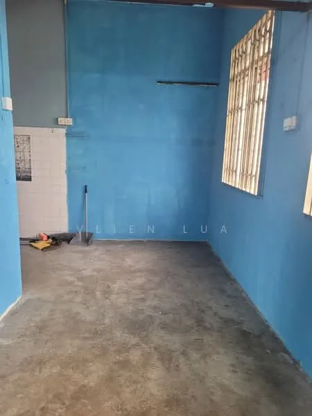 Room features: blue painted walls, concrete flooring, window with metal bars, exposed ceiling, light source not visible.