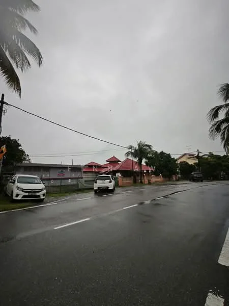 Exterior type: detached bungalow; features: red pitched tile roof, white painted facade, surrounded by palm trees, manicured lawn, single-storey, driveway with interlocking pavers; style: tropical-modern.