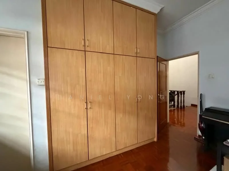 Room features: built-in wooden wardrobe, light wood finish, four cabinet doors, wooden flooring, white walls, door leading to another room, door frame, baseboard.