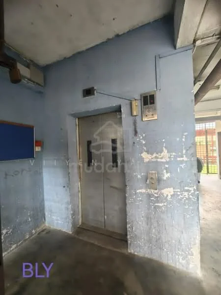 Room features: elevator doors, blue painted walls, exposed concrete ceiling, concrete flooring, elevator control panel, light fixture, wall-mounted notice board, wear and tear on walls; style: industrial.