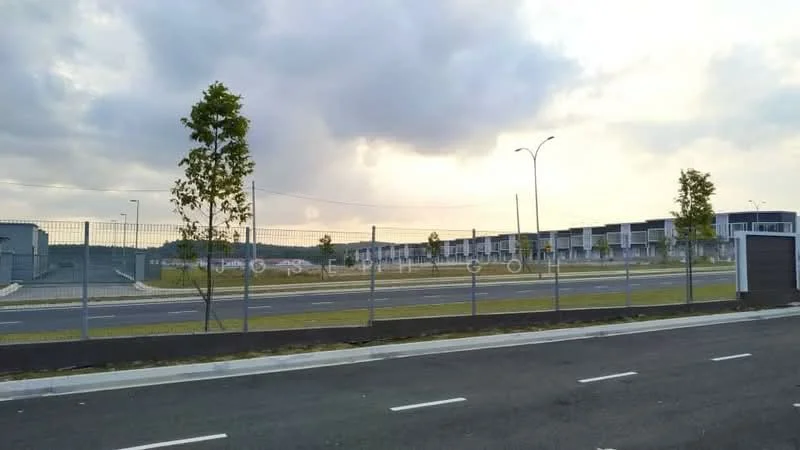 Exterior features: fenced perimeter, asphalt road, landscaped green area, street lighting, multiple buildings in the background, cloudy sky, open space, paved walkway; style: modern.