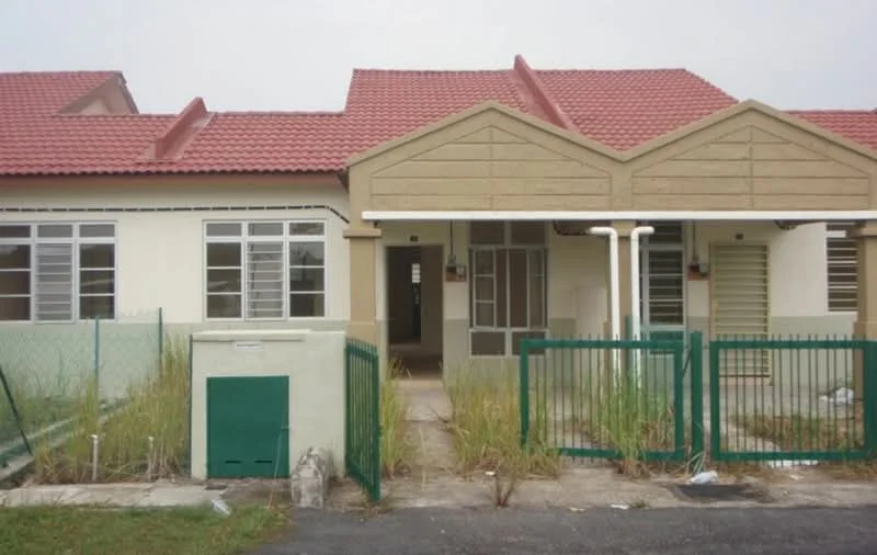 Exterior type: linked terrace house; features: red pitched tile roof, cream painted facade, green metal fence, front porch area, two front doors, multiple windows with white frames, grass and weeds in front yard, concrete pathway, utility box on the side; style: modern.