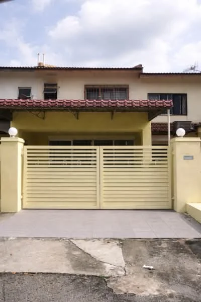 Exterior type: linked terrace house; features: yellow painted facade, red tiled roof, sliding gate, paved driveway, two round outdoor lights, front porch area, windows with grills, single-storey, concrete wall, manicured lawn; style: modern.