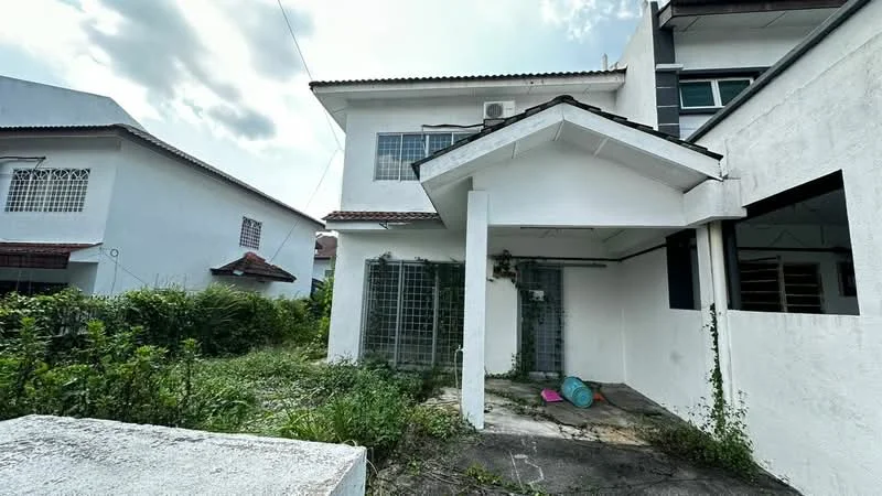 Exterior type: detached bungalow; features: white painted facade, flat roof, single-storey, overgrown garden, concrete pathway, metal security grille, large windows, porch area, surrounded by greenery; style: modern.