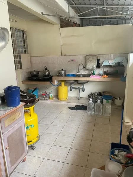 Kitchen features: white tiled walls, light-colored tiled flooring, single-bowl stainless-steel sink, chrome pull-down faucet, kitchen countertop with backsplash, gas stove with pot, yellow gas cylinder, multiple water bottles, wooden cabinet, open shelving, window with metal grille, kitchen utensils and cookware.