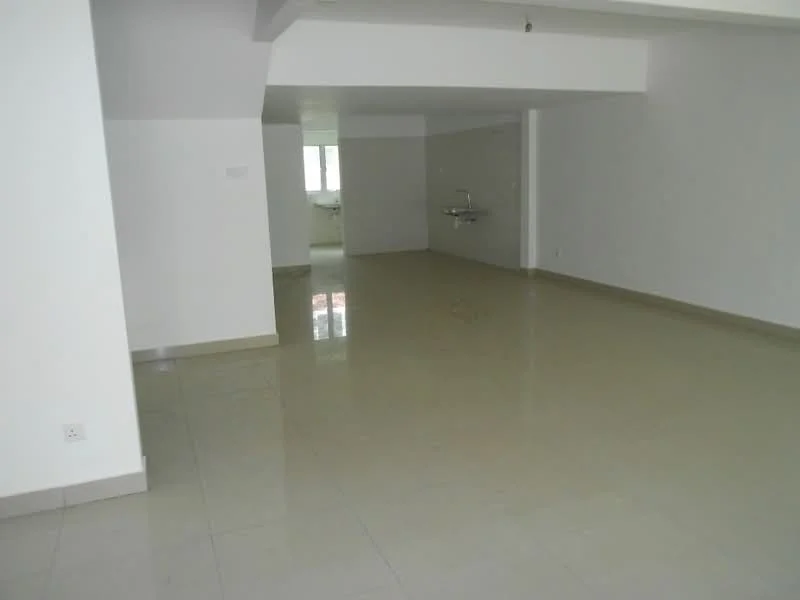 Room features: white painted walls, glossy ceramic tile flooring, large windows allowing natural light, sink mounted on wall, open layout, neutral color scheme, no visible furniture, high ceiling; style: modern.