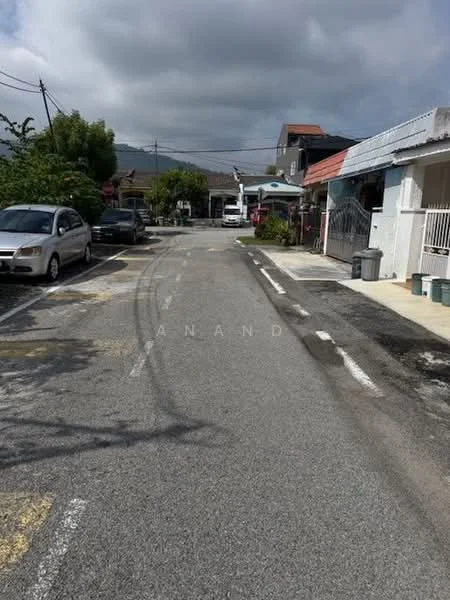 Exterior features: paved road, residential street, surrounded by houses, street signs, utility poles, trees along the road, cloudy sky.