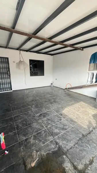 Room features: black tiled flooring, white painted walls, metal ceiling beams, large window, door with security grille, natural light from window, unfurnished space, corner with plumbing visible; style: modern.