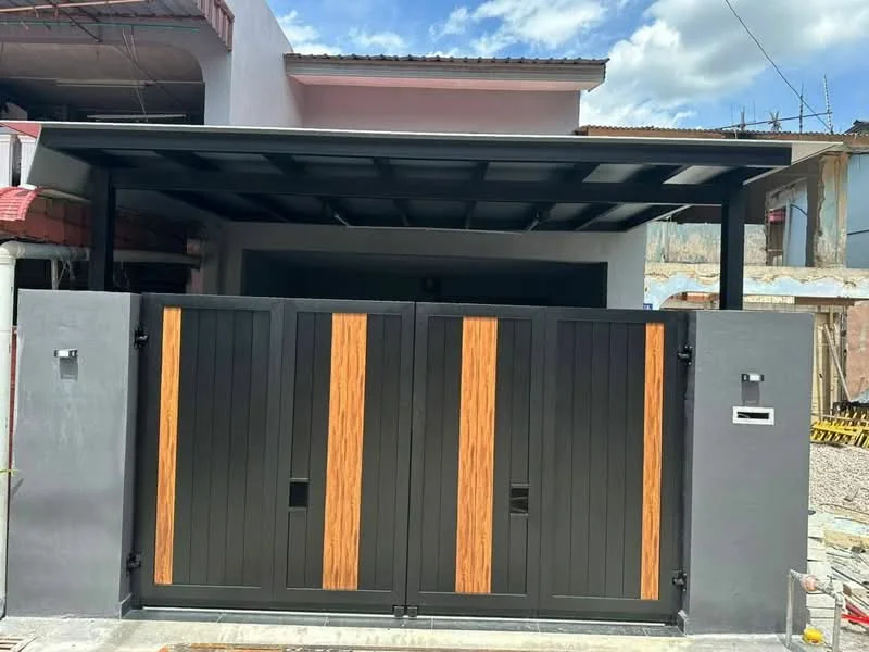 Exterior features: black metal gate with wooden accents, car porch with roof, concrete driveway, grey exterior wall, intercom panel, mailbox, surrounding construction site, clear blue sky; style: modern.