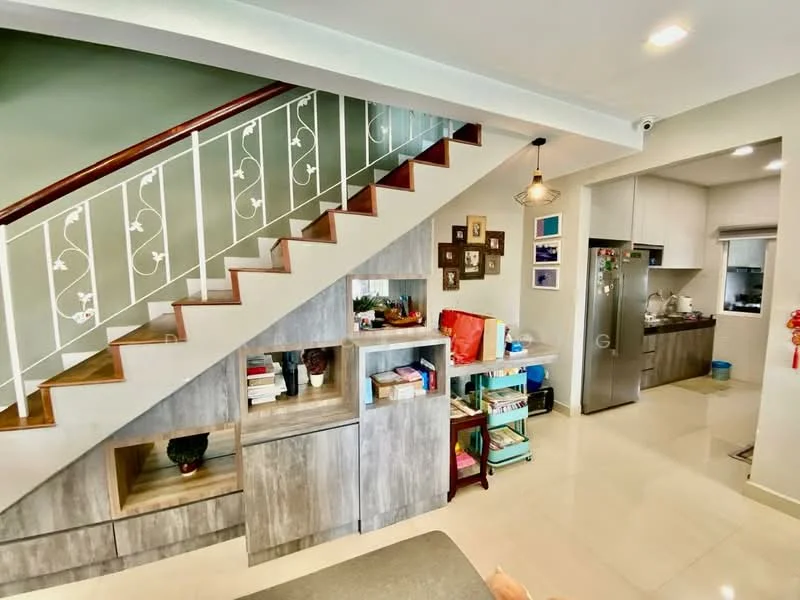 Living features: staircase with wooden steps and white railing, grey wood cabinetry, open shelving, decorative wall art, cream tiled flooring, recessed ceiling lights, pendant light fixture, kitchen area visible in background, green accent wall; style: modern. Kitchen features: stainless-steel refrigerator, built-in cabinetry, countertop with workspace, window above sink, light-colored cabinetry; style: modern.