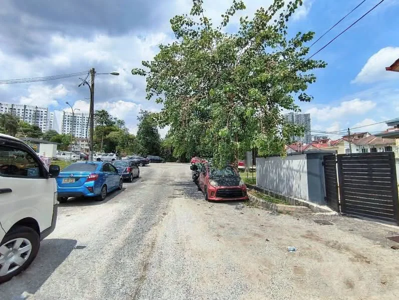 Exterior features: gravel road, mature trees, parked cars, residential buildings in background, clear blue sky, power lines.