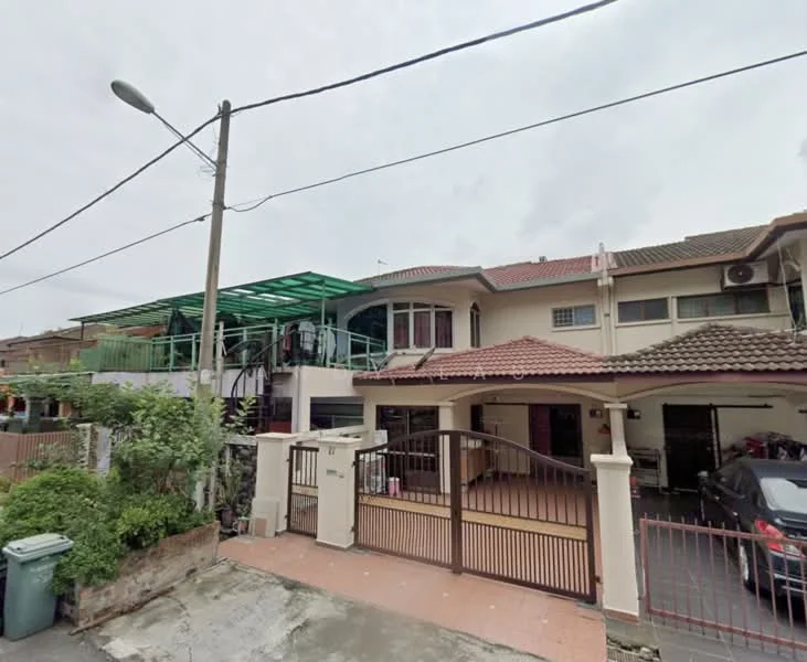 Exterior type: semi-detached house; features: two-storey structure, red tiled roof, cream painted facade, green awning over balcony, front gate with metal bars, paved driveway, manicured garden, car porch, visible parking area, outdoor staircase, surrounded by greenery; style: modern.