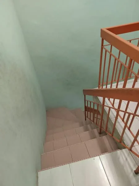 Room features: green painted walls, tile flooring, orange metal railing, staircase leading down.