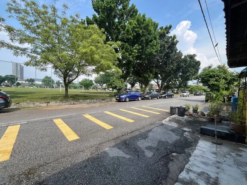Exterior features: tree-lined street, yellow pedestrian crossing, asphalt road, parked cars, green grass area, sidewalk, mature trees, residential buildings in background.