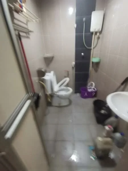 Bathroom features: white toilet, shower with wall-mounted shower head, sink with chrome faucet, grey tiled walls, grey tiled flooring, wall-mounted water heater, clothes drying rack, plastic storage container, purple bucket.