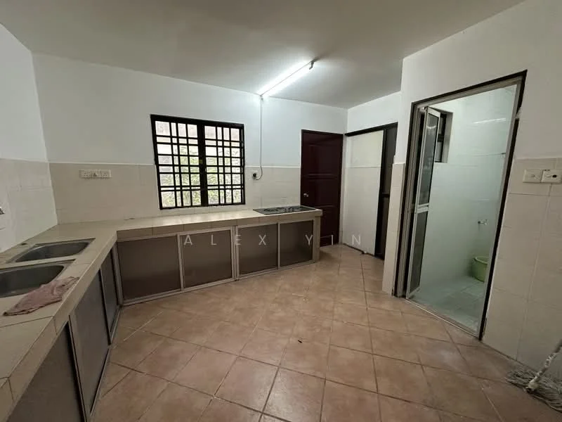 Kitchen features: L-shaped countertop, double-bowl stainless-steel sink, chrome pull-down faucet, cream tiled backsplash, light beige tiled flooring, white painted walls, window with black grille, built-in cabinetry, door leading to bathroom, door leading to hallway. Room features: light green toilet, white tiled walls, light grey tiled flooring.