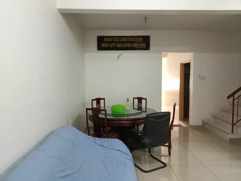 Living features: white painted walls, glossy tile flooring, round dining table, 4 dining chairs, sofa with blue cover, black office chair, staircase leading to upper floor, signboard on wall.