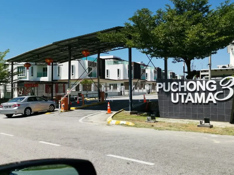 Exterior type: gated community; features: main entrance gate, guard house at entrance, paved driveway, landscaped greenery, street signage, surrounding residential buildings, traffic cones, canopy structure; style: modern.