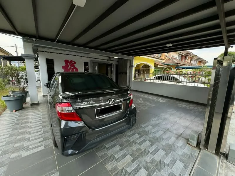 Exterior type: car porch; features: covered car porch, grey tiled flooring, metal roof, decorative wall with red character, fenced perimeter, landscaped planters, access gate, adjacent residential buildings; style: modern.