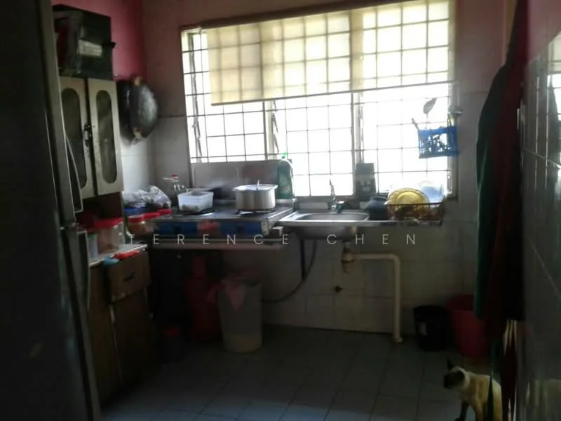 Kitchen features: double-bowl stainless-steel sink, chrome pull-down faucet, wood cabinetry with glass doors, white tiled backsplash, grey tiled flooring, window with sheer curtains, countertop with various kitchen utensils, plastic waste bin, open shelving with dishes, kitchen appliances visible, light fixture on ceiling.